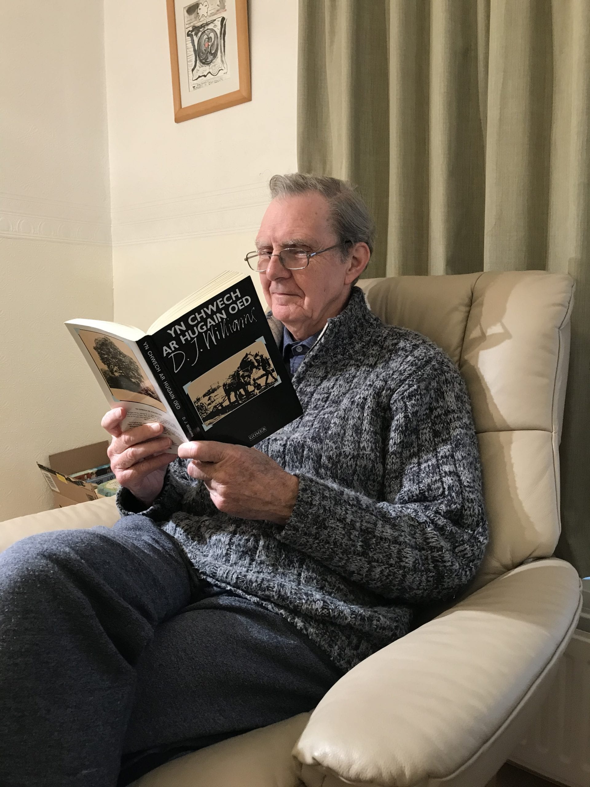 Professor M. Wynn Thomas, Chair of the Books Council, reading a book.