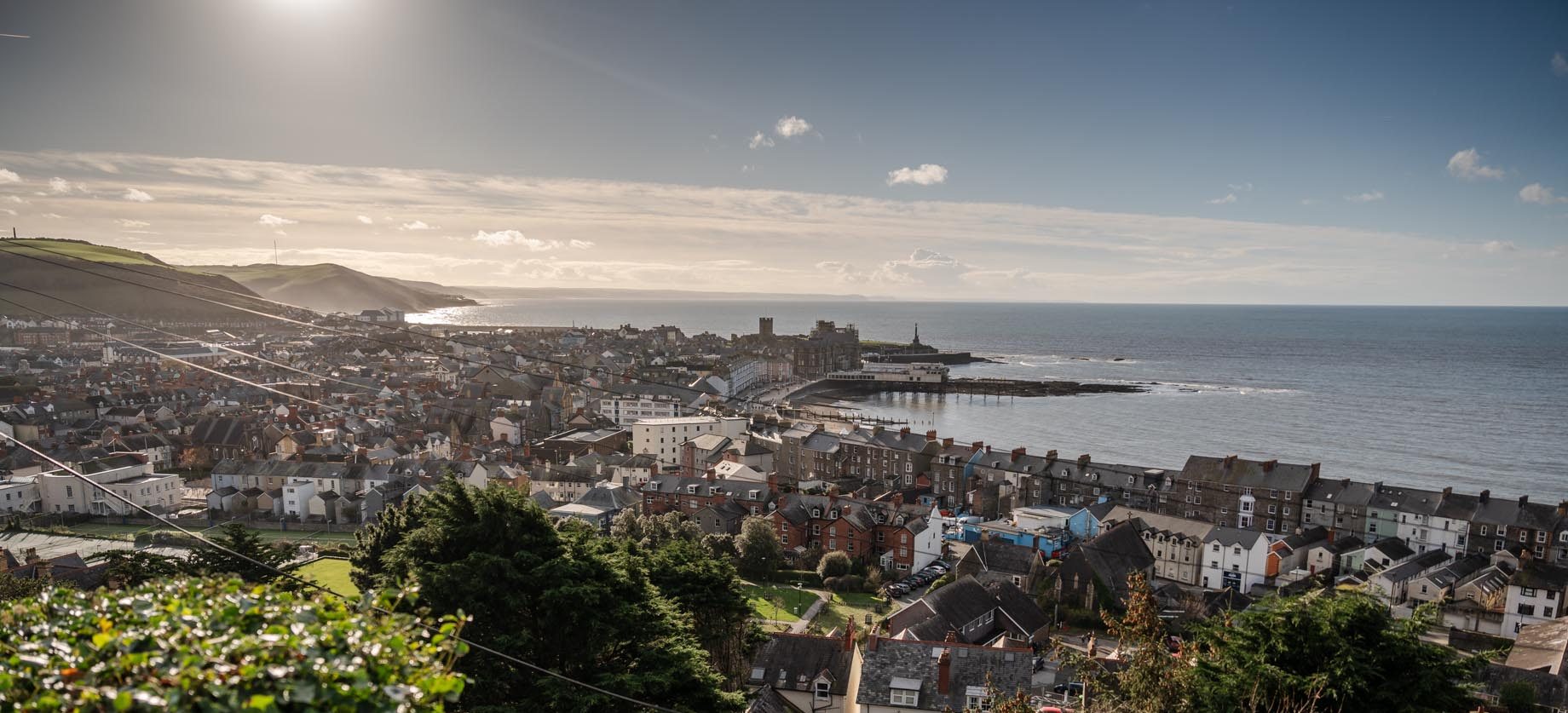 A view overlooking Aberystwyth on a sunny day with Ceredigion Bay visible.